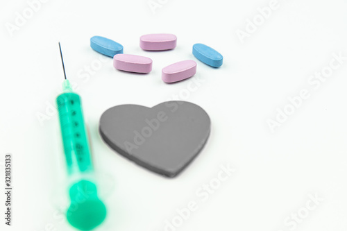 Strzykawka serce oraz tabletki na białym tle