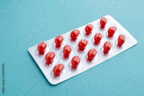 Slika na platnu Blister with red pills at blue background