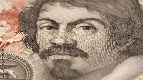 Caravaggio portrait on 100000 italian lire banknote rotating. Famous Italian renaissance painter. Low angle, macro. 4K, 422 10 bit photo