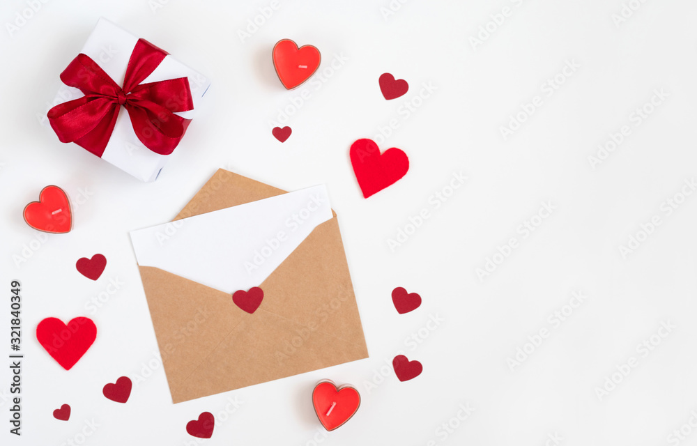 Valentines day composition. Greeting card with hearts, candles, gift and letter in a paper envelope on a white background. Valentines day composition. Greeting card with hearts, candles, gift and letter in a paper envelope on a white background.