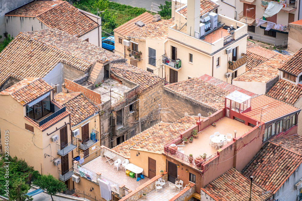 Panorama view on cityscape of Cefalu from drone. Roofs of houses with terraces close-up. Sicily, Italy