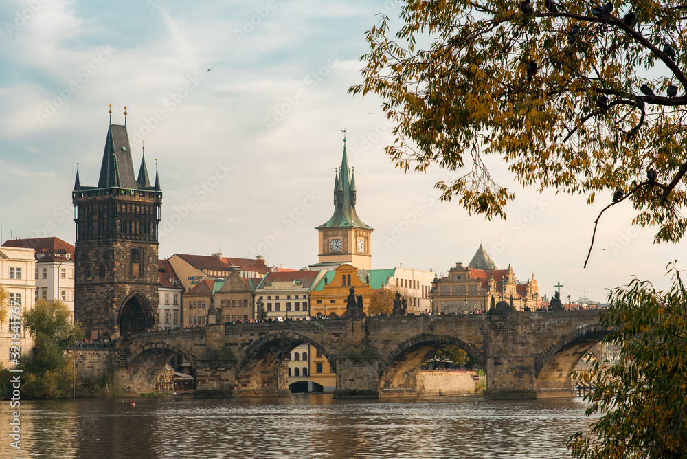 View of the Charles Bridge Through Autumn Leaves in Prague, Czechia