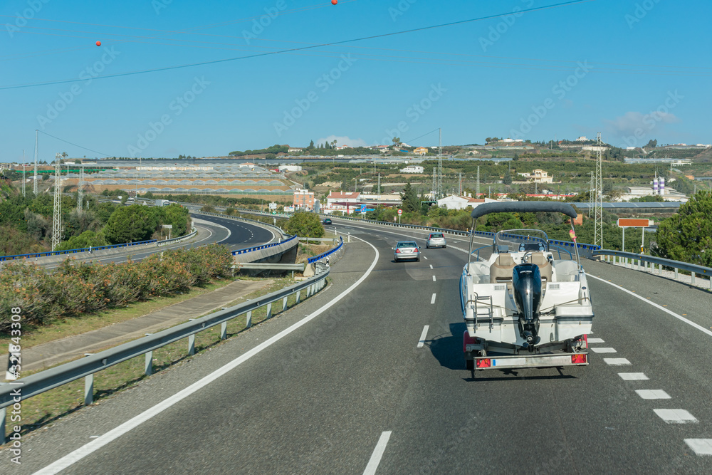 Motor boat transported by a car on the road Motor boat transported by a car on the road