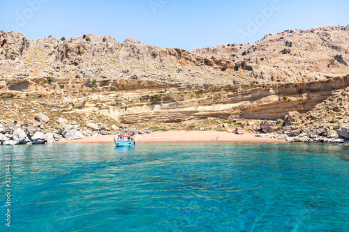 Tourist boat anchored by Red Sand beach (Rhodes, Greece)