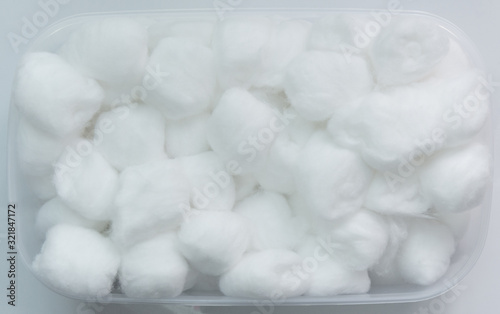 sterile cotton balls in white plastic box on white background.