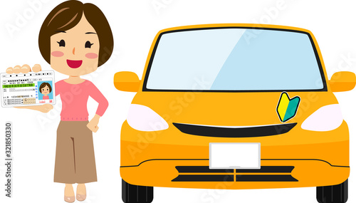 車の横で運転免許証（グリーン）を見せる若い女性