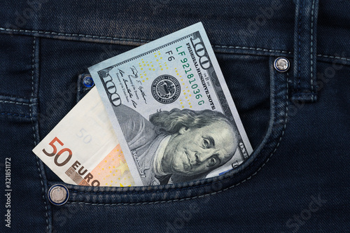 Fifty euro and one hundred dollar banknote money in pocket jeans pants background texture. euro and dollar close up