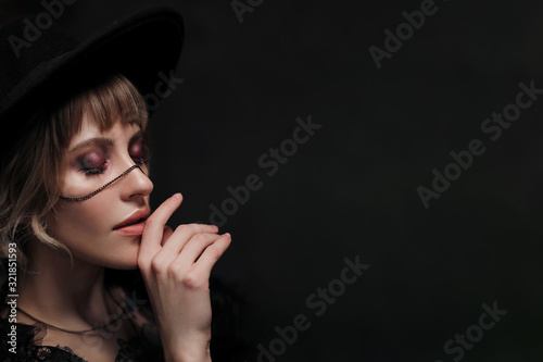 Young beautiful blonde woman in a black hat and dress.
