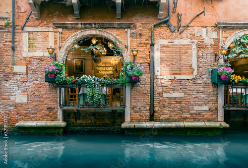 Traditional Italian Restaurant along Scenic Venetian Canal in Venice, Italy photo