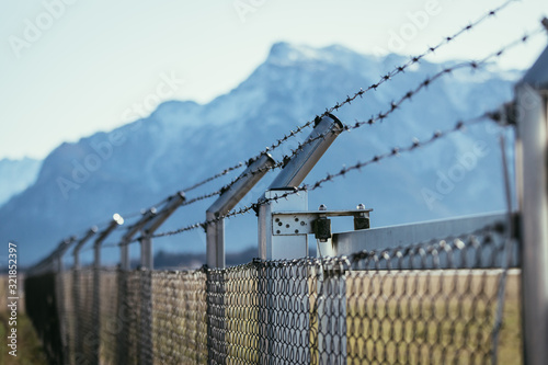 Military fence with barbed wire. Restricted area.