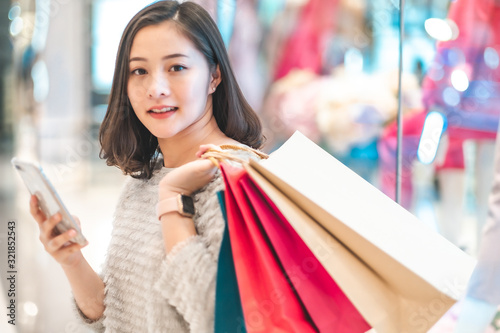 Asain woman in shopping. Happy woman with shopping bags enjoying in shopping.lifestyle concept.Smiling girl holding colour paper bag.