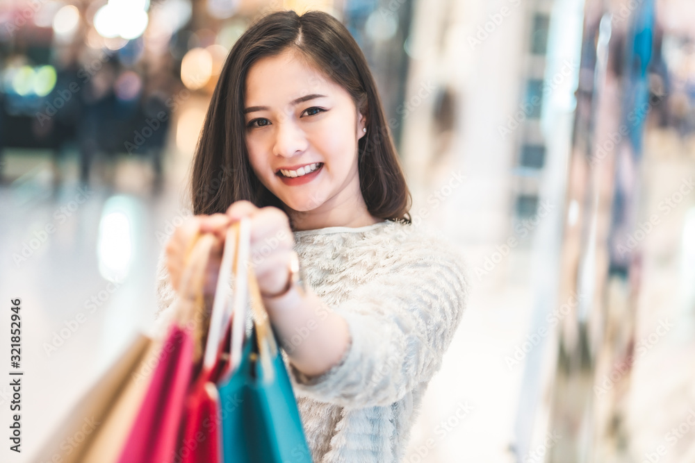 Asain woman in shopping. Happy woman with shopping bags enjoying in shopping.lifestyle concept.Smiling girl holding colour paper bag. Asain woman in shopping. Happy woman with shopping bags enjoying in shopping.lifestyle concept.Smiling girl holding colour paper bag.