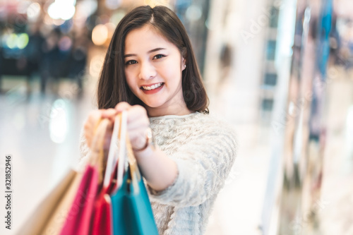 Asain woman in shopping. Happy woman with shopping bags enjoying in shopping.lifestyle concept.Smiling girl holding colour paper bag.