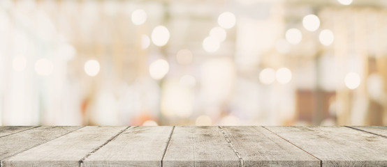 Empty wood table and blurred light table in shopping mall with bokeh background. product display template.