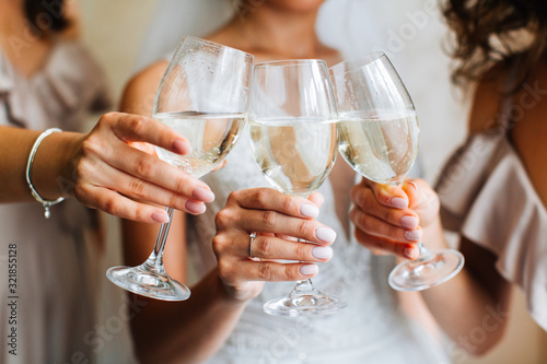 Closeup of bride and bridesmaids holding a glass of champagne in her hand