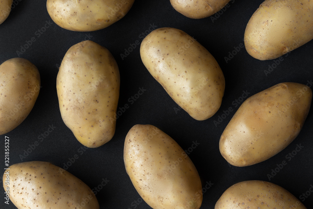 Sprinkle raw organic potatoes on dark background Sprinkle raw organic potatoes on dark background