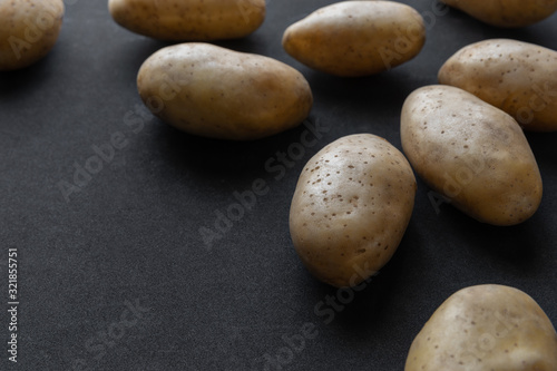 Frame of raw organic potatoes on dark background