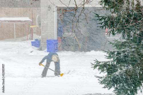 Bilde på lerret Person shoveling during a snowstorm