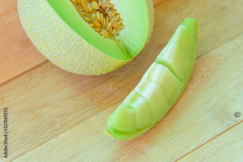 Fresh yeloow galia melon on wood plate photo