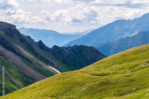 Panorama of picturesque blue mountainsides and green alpine meadows, Austria