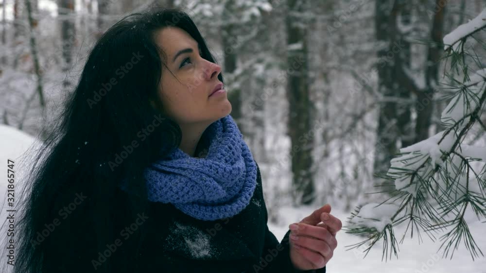 Female Hand Touches Pine Tree Branches Covered With Snow. Holidays Vacation Walking Hiking in Winter Forest During Snowfall. Frost Weather In the Wood. Slow motion 60 fps