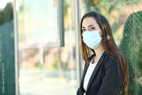 Woman wearing a mask to prevent contagion in a bus stop