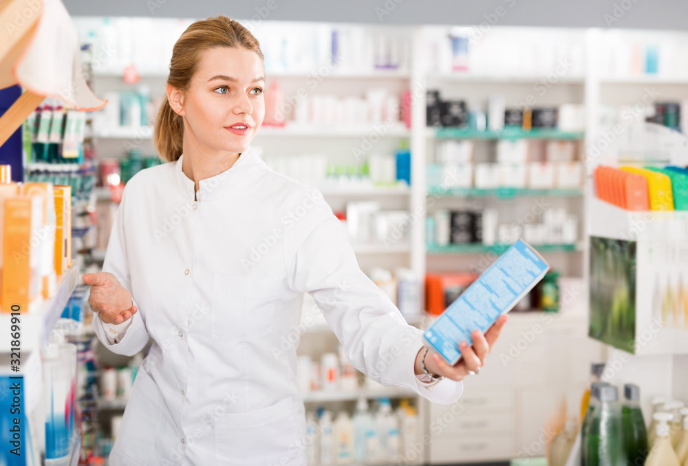 Female pharmacist offering assistance at counter in pharmacy