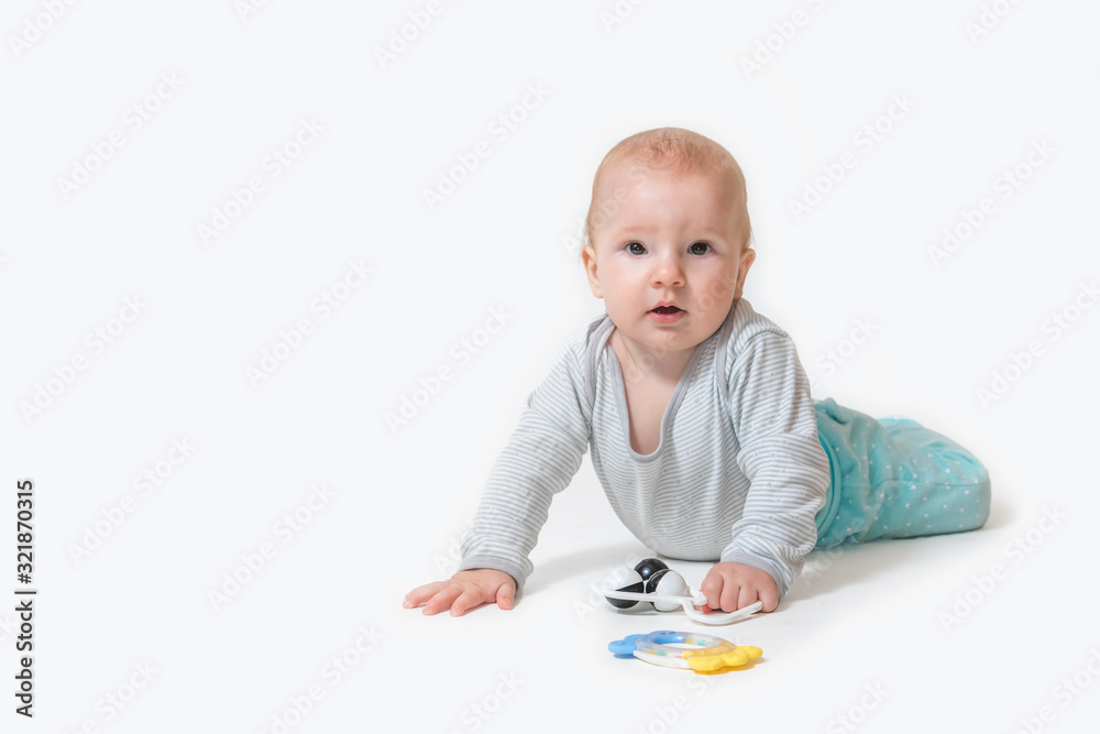 Smiling cute little baby boy is lying leaning hands on the floor and looking at the camera. All is on the white background Smiling cute little baby boy is lying leaning hands on the floor and looking at the camera. All is on the white background