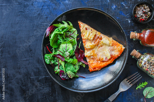 slice of pizza and salad leaves in a plate on the table (tasty snack) menu concept background. top view. copy space