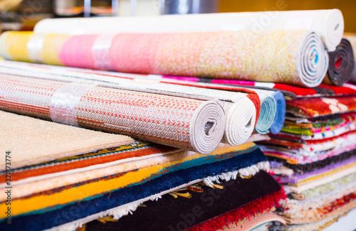 Stack of traditional colorful carpets in carpet shop