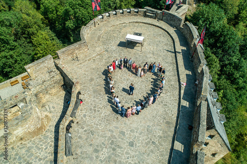 Wedding guests lined up in the shape of heart with bride and groom marriage people photo