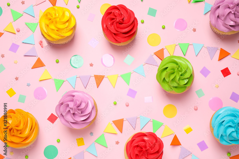 Colorful birthday cupcakes on light pink background, flat lay Colorful birthday cupcakes on light pink background, flat lay
