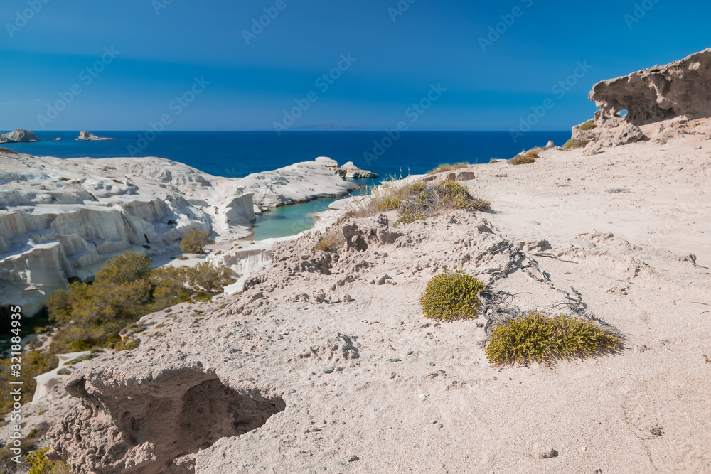  Amazing landscape with white volcanic rocks at Sarakiniko beach. Turquoise Aegean sea and blue sunny sky. Unique mediterranean nature of Milos island, Greece. Travel destination and vacation paradise