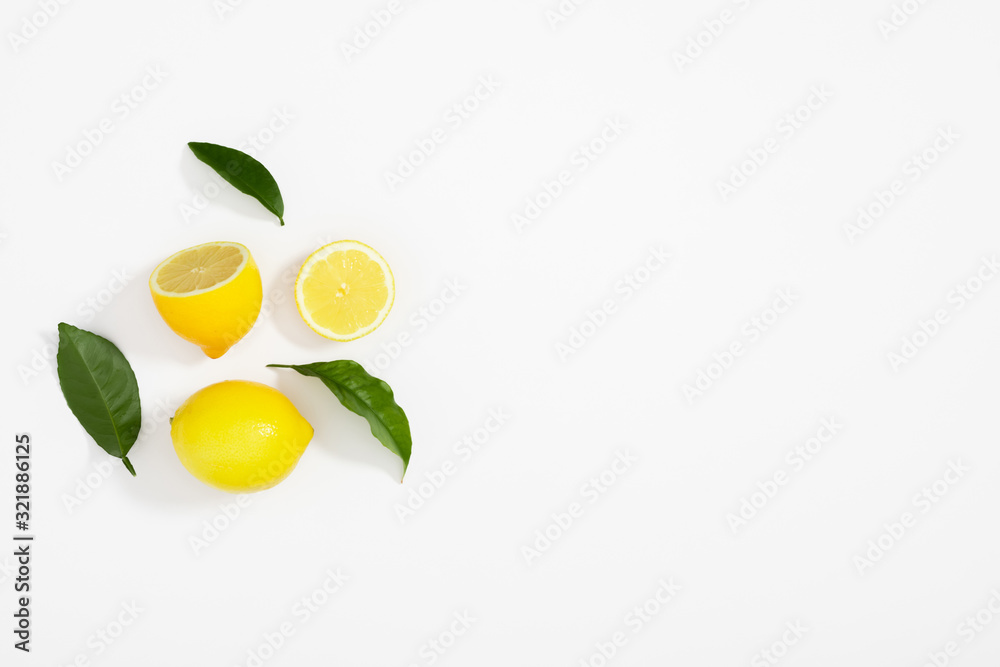 Creative pattern made of lemon and leaves. Lemon on white background. Food concept. Flat lay, top view, copy space Creative pattern made of lemon and leaves. Lemon on white background. Food concept. Flat lay, top view, copy space