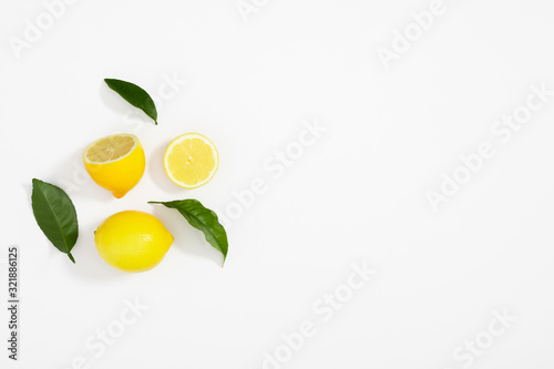 Creative pattern made of lemon and leaves. Lemon on white background. Food concept. Flat lay, top view, copy space