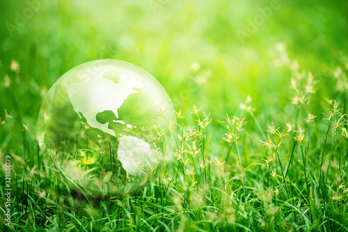 Earth glass on green grass in sunlight, Love and Save the World for the Next Generation concept, Earth day concept
