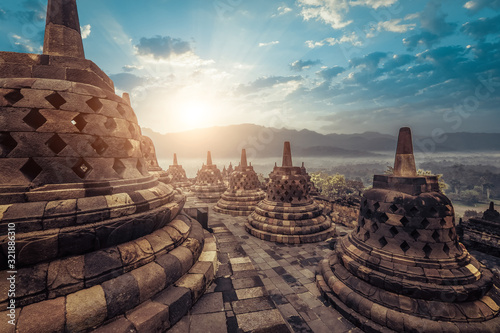 Amazing view of stone stupas at ancient Borobudur Buddhist temple against beautiful landscape on background. Great religious architecture. Magelang, Central Java, Indonesia
