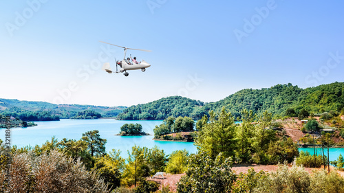 White gyroplane in blue sky over the Manavgats Lake, Turkey photo