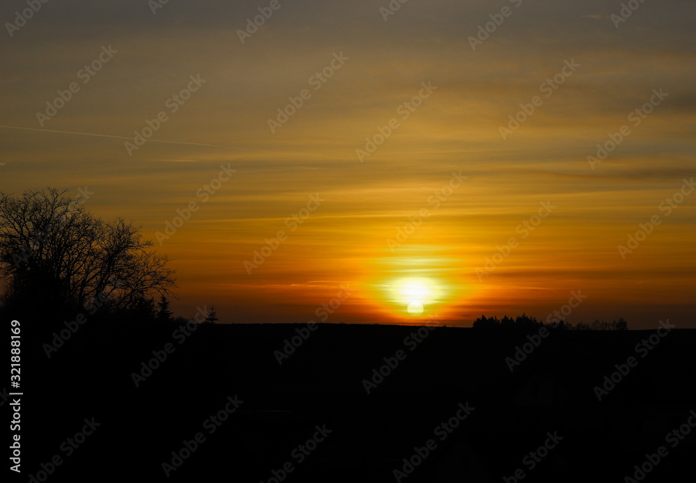 Puesta de sol en los campos de Austria con la silueta de los árboles en el horizonte. Puesta de sol en los campos de Austria con la silueta de los árboles en el horizonte.