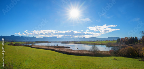 rural landscape with moor lake riegsee and bavarian alps, bright sunshine. photo