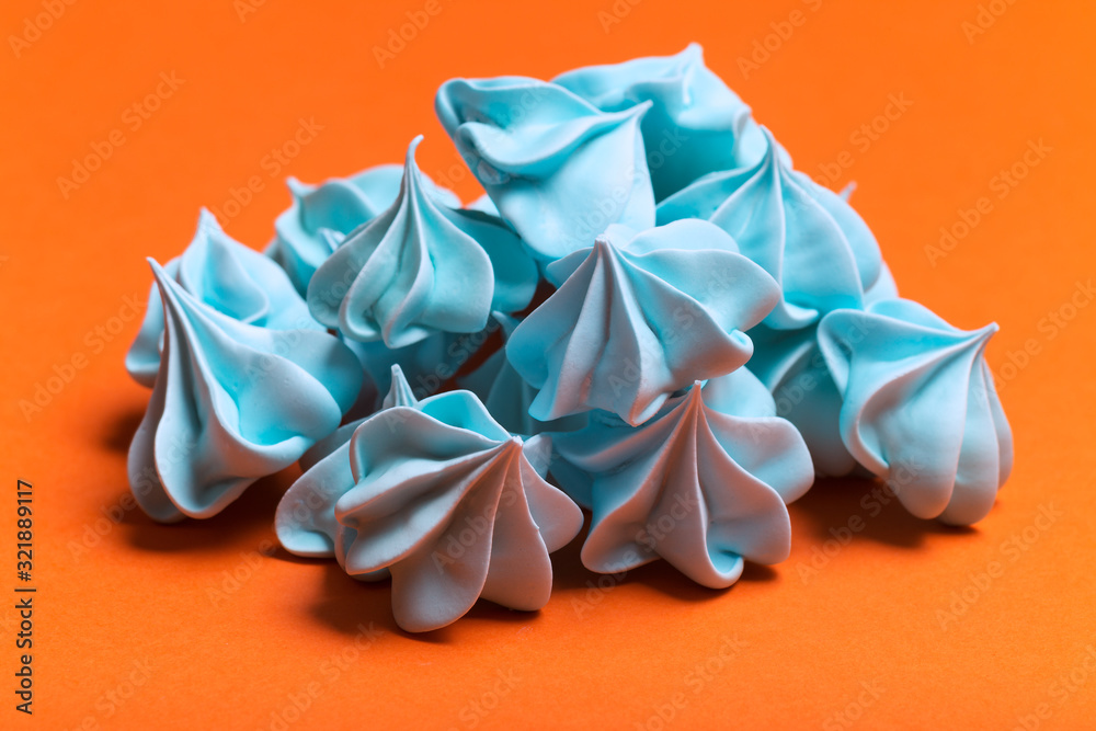 Fototapeta premium Sweet blue meringues on orange background