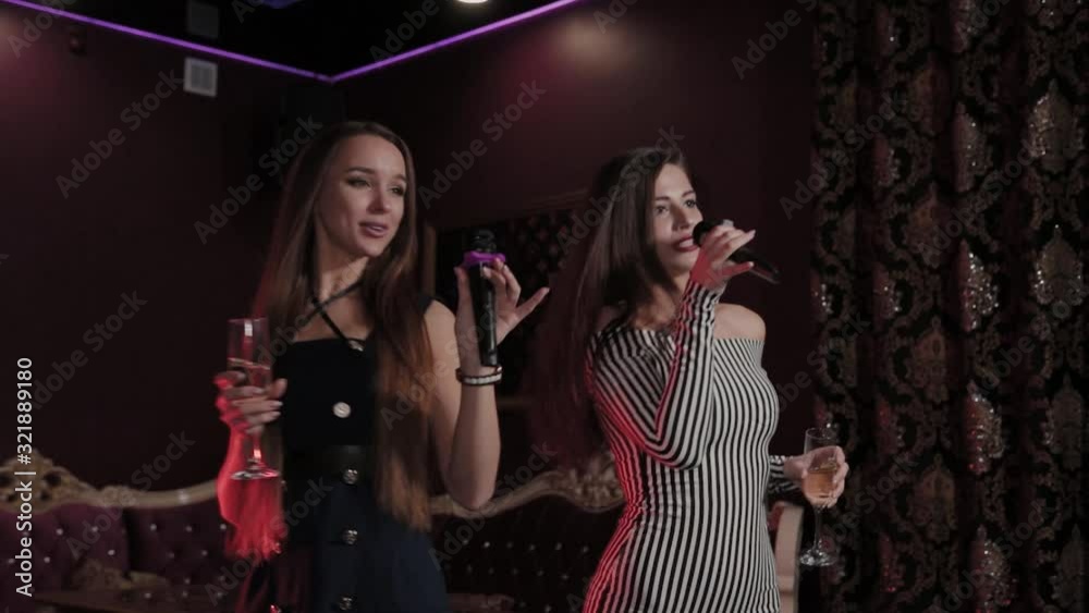 Beautiful young girls singing in karaoke club. Beautiful young girls singing in karaoke club.
