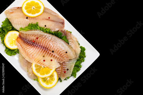 Whitefish Tilapia Fish Raw Fillet Isolated on Black Background. Selective focus.