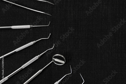 several dental instruments on black
