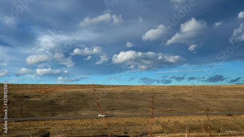 Car driving in highway against a backdrop of dramatic clouds over the open space of Boulder, Colorado photo