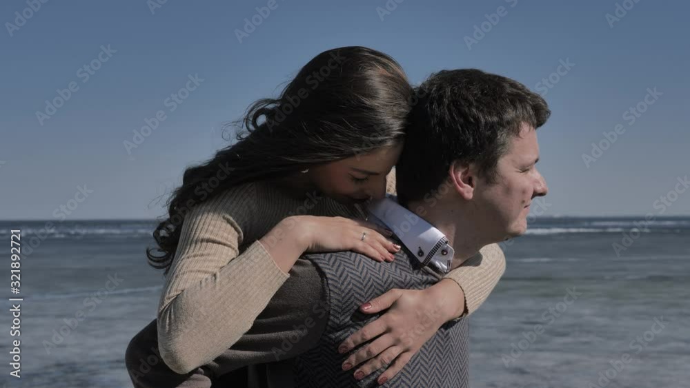 Young couple fooling around next to an ice-covered river, sunny spring day. Young couple fooling around next to an ice-covered river, sunny spring day.