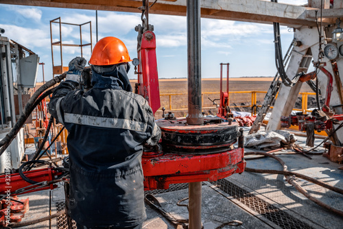Offshore oil rig worker prepare tool and equipment for perforation oil and gas well at wellhead platform. Making up a drill pipe connection. A view for drill pipe connection from between the stands.