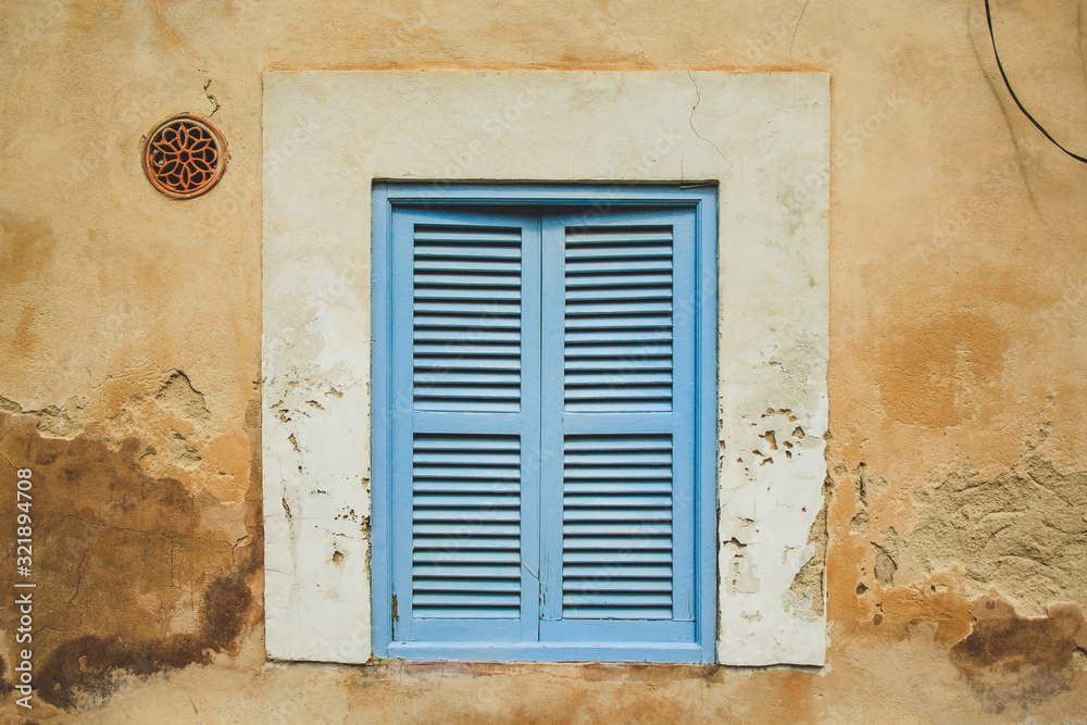 old rustic window with grey closed shutters in Mallorca, Spain