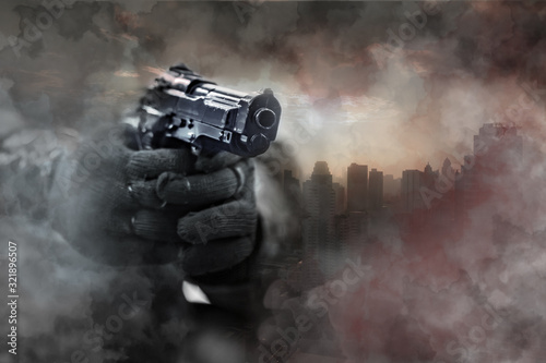 Obraz na plátně Gun in gunman's hand with city background