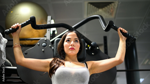 Woman using a chest press machine in a gym